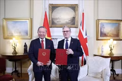 El secretario general To Lam y el primer ministro del Reino Unido, Keir Starmer, intercambian una declaración conjunta sobre la elevación de los nexos bilaterales a una asociación estratégica integral. (Foto: VNA) 