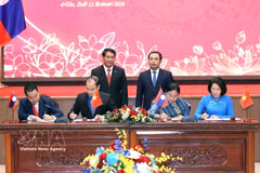 El secretario del Comité del Partido Comunista de Vietnam en Hanoi, Tran Duc Thang, y el jefe del Comité del Partido Popular Revolucionario de Laos en Vientiane, Athsaphangthong Siphandone, presencian la ceremonia de la firma del memorando del entendimiento. (Foto: VNA)