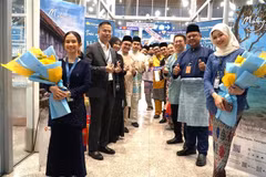 Representantes de Vietnam Airlines, Departamento General de Turismo de Malasia y el Aeropuerto Internacional de Kuala Lumpur esperan para recibir a los primeros pasajeros del vuelo Hanoi-Kuala Lumpur en la noche del 1 de abril de 2025. (Fuente: VNA)