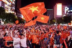 Los aficionados en la calle peatonal Nguyen Hue estallan de emoción cuando el delantero Nguyen Xuan Son anota el primero gol del partido. (Fuente: VNA)