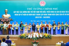 El primer ministro Pham Minh Chinh entrega flores para felicitar a los jóvenes vietnamitas destacados. (Fuente: VNA)
