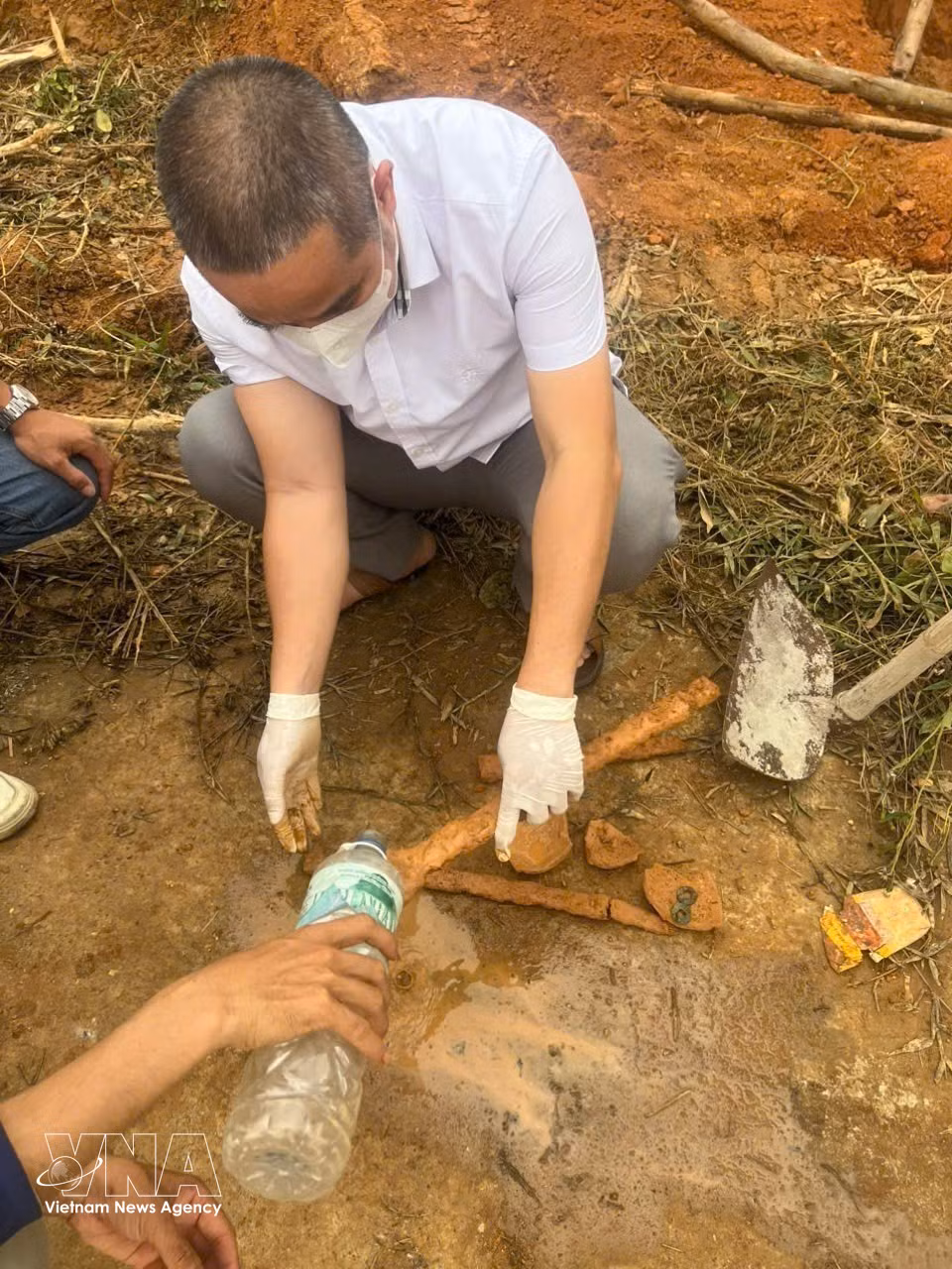 Especialistas descubren dos espadas de hierro durante la excavación de la tumba. (Foto: VNA)