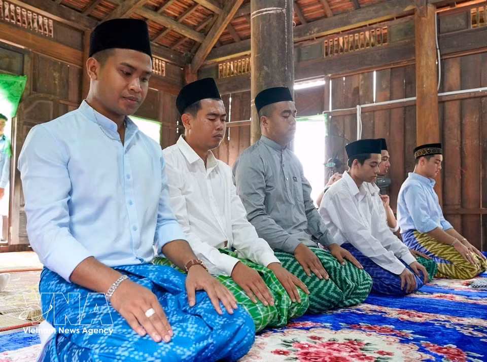 Hombres musulmanes Cham, vestidos con trajes tradicionales, acuden juntos a la mezquita para realizar las oraciones rituales. (Foto: VNA)