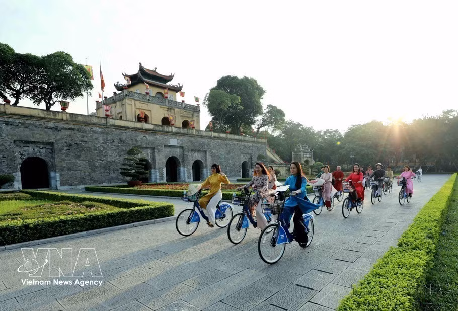 Mujeres de Hanoi, vestidas con el traje tradicional Ao Dai, recorren en bicicleta los sitios patrimoniales de la ciudad durante el primer evento "Ao Dai conecta el turismo y el patrimonio de Hanoi" en 2023. (Foto: VNA)