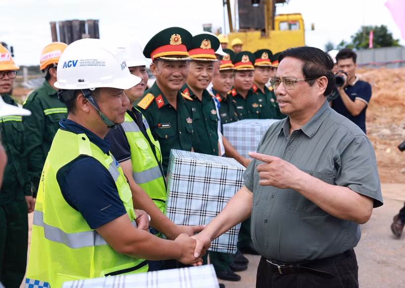 El primer ministro Pham Minh Chinh (derecha) se reúne con las unidades encargadas de la construcción de la terminal T2 del Aeropuerto Dong Hoi (Foto: VNA)