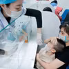 El personal médico toma muestras de gripe para pacientes pediátricos. (Foto: VNA)
