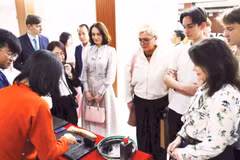 Los turistas extranjeros disfrutan al experimentar la impresión de xilografías. (Fuente: nhandan.vn)
