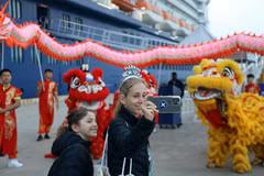 Los turistas del Celebrity Solstice disfrutan tomándose fotos con un equipo de danza del león y el dragón. (Fuente: VNA)