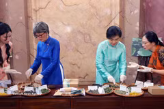 Ngo Phuong Ly, esposa del secretario general del Partido Comunista y presidente de Vietnam, To Lam, y Caroline Parmelin, cónyuge del presidente suizo, Guy Parmelin, participan en la elaboración de almohadillas térmicas tradicionales con hierbas medicinales. (Fuente: VNA)