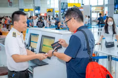 Personal de seguridad aérea verifica los documentos del pasajero antes de abordar el avión. (Fuente: VietnamPlus) 