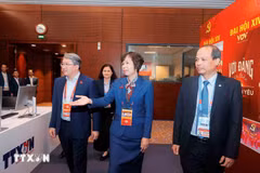 El miembro del Comité Central del Partido y ministro de Justicia, Nguyen Hai Ninh (izq.), visita el área de trabajo de la Agencia Vietnamita de Noticias en el centro de prensa del XIV Congreso Nacional del Partido. (Fuente: VNA)