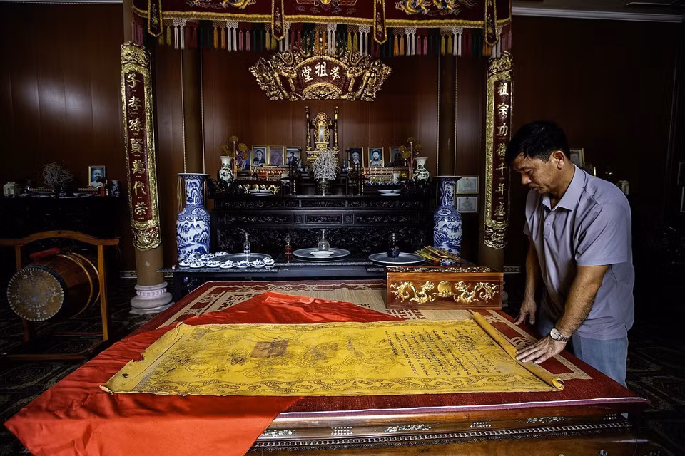 Dinh Cong Thao, bisnieto de Dinh Cong Thinh - quien fue gobernador de Hoa Binh entre 1919 y 1928 - junto a los documentos oficiales reales que reconocen a la familia Dinh Cong. (Foto: VNA)