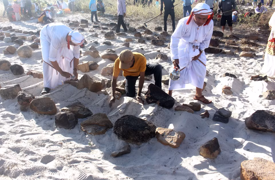 El ritual de purificación de las tumbas antes de leer los rezos. Foto: VNA
