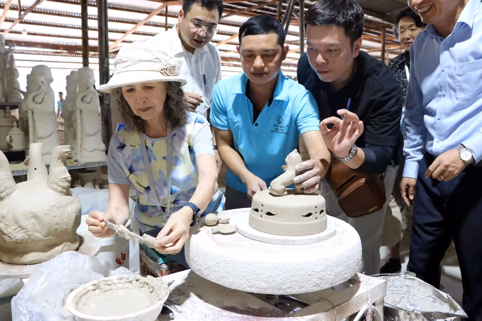 Experiencia práctica: los invitados aplican motivos decorativos en piezas sin esmaltar. (Foto: VNA)
