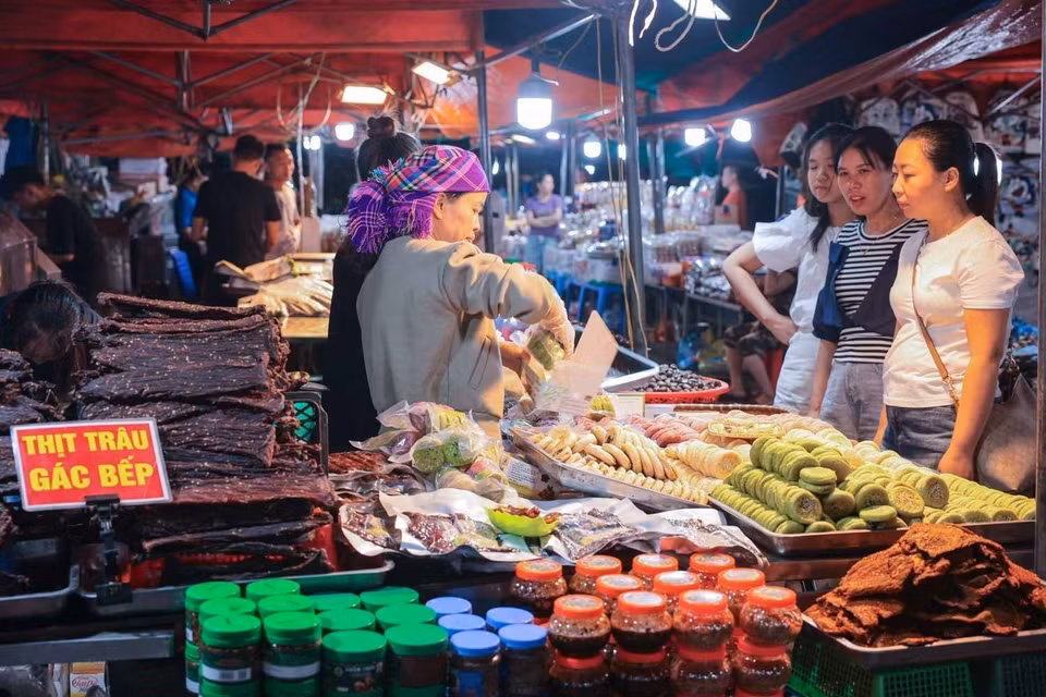 Los visitantes buscan adquirir especialidades locales de Lao Cai. Foto: VNA