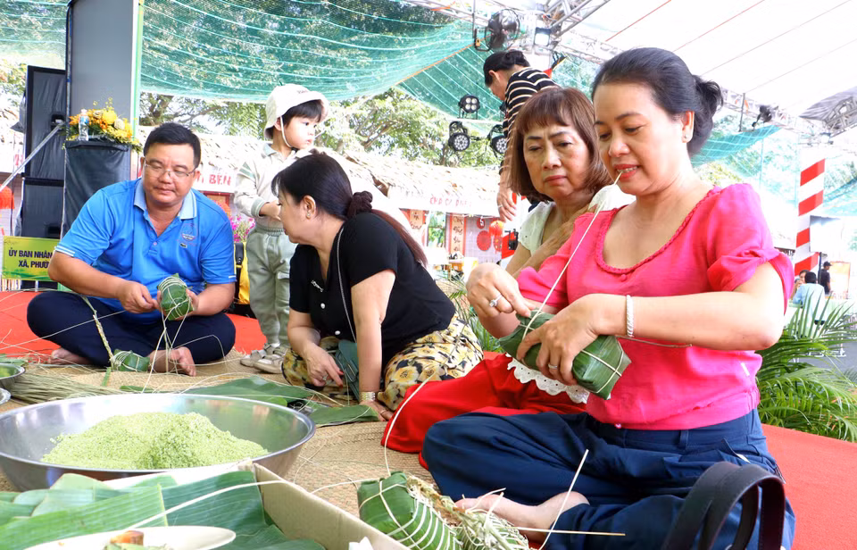 Visitantes se unen a los locales para aprender y participar en la tradicional preparación del “banh tet” o pastel cilíndrico de arroz glutinoso. (Foto: VNA)