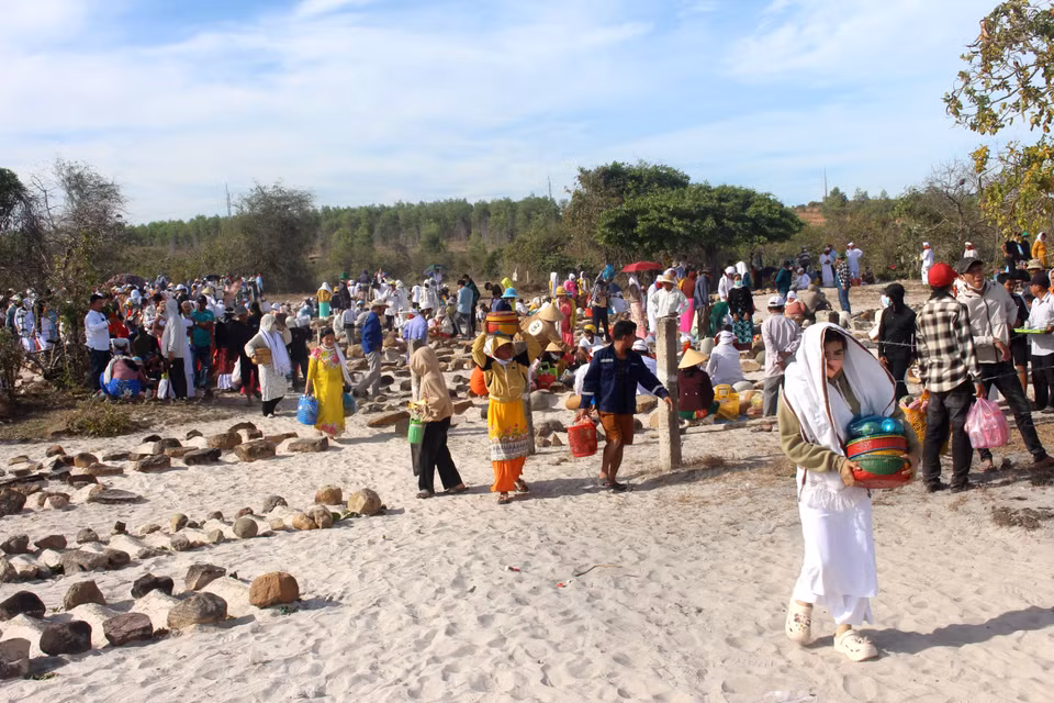 La comunidad Cham viste ropa tradicional y lleva ofrendas mientras realizan el ritual de limpieza de tumbas. Foto: VNA