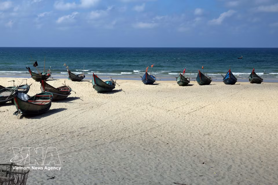 Pequeñas embarcaciones pesqueras descansan sobre la fina arena blanca tras regresar de faenar en el mar. (Foto: VNA)