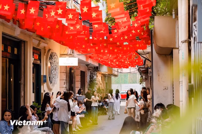 Además, los pequeños callejones, cubiertos de banderas, también se han convertido en lugares ideales para que los jóvenes hagan check-in. (Foto: Vietnam+)
