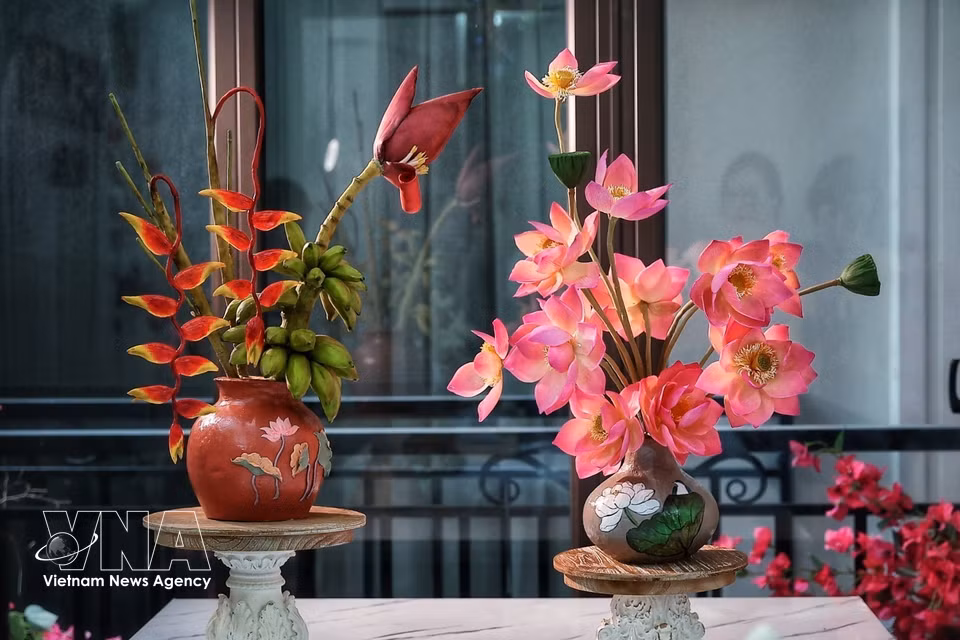 Los jarrones de flores de loto y de platanera, elaborados con ingredientes para pasteles de luna y tò he, presentan diferentes formas y tonalidades, hasta el punto de que resulta difícil reconocer que son productos comestibles. (Foto: VNA)