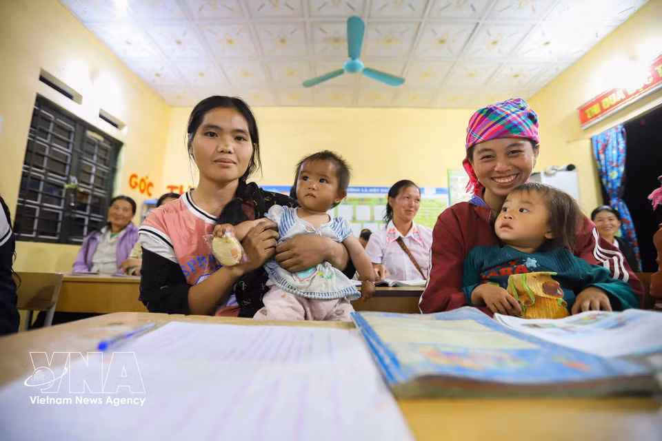 Song Thi Khua y Hang Thi Cha asisten a las clases nocturnas acompañadas por sus hijos. (Foto: VNA)