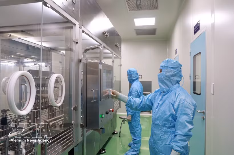 Investigadores del Instituto de Vacunas y Productos Biológicos Médicos operan equipos en el proceso de producción de vacunas. (Foto ilustrativa: VNA)