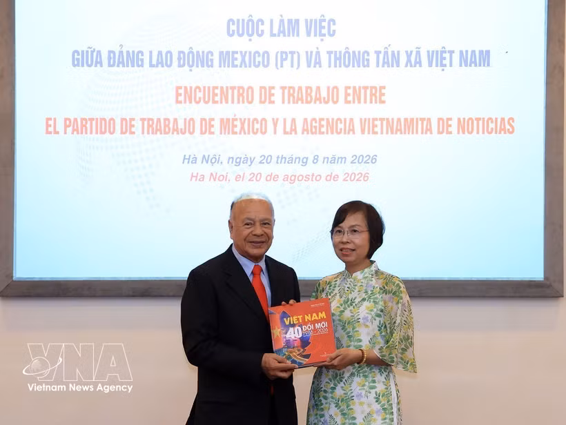 La directora general de la VNA, Vu Viet Trang, obsequia un libro fotográfico al coordinador nacional del PT, Alberto Anaya Gutiérrez. (Foto: VNA)