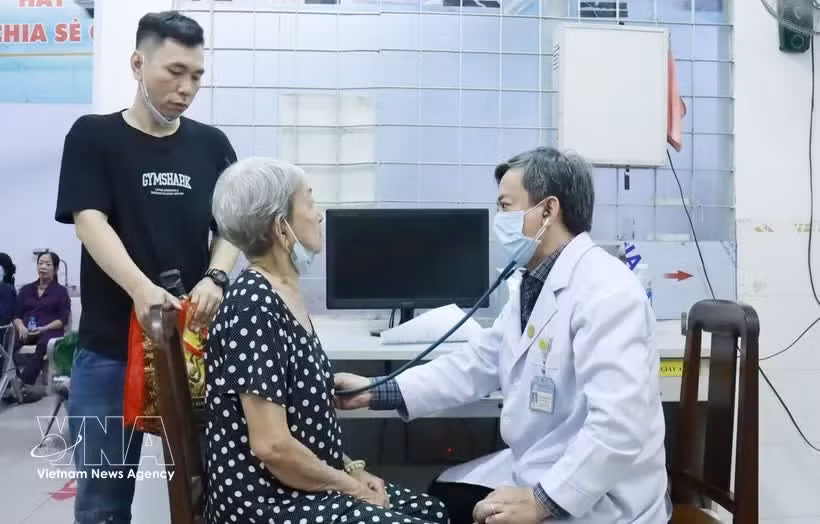 Un médico del Hospital Cho Ray realiza un examen de salud a una anciana en el centro médico del barrio de Cho Lon. (Foto: VNA)