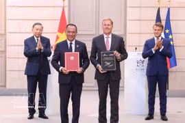 El secretario general del Partido Comunista y presidente de Vietnam, To Lam, y el presidente francés, Emmanuel Macron, presencian la ceremonia de entrega de varios documentos de cooperación bilateral. Foto: VNA
