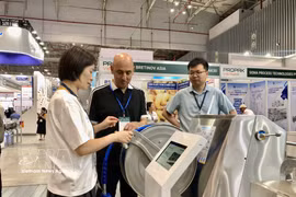 Las empresas muestran maquinaria moderna a los visitantes de la exposición. (Foto: VNA)