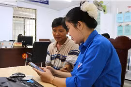 Una jóven de la Unión de Jóvenes Comunistas Ho Chi Minh de la comuna de Tuy An Nam, provincia de Dak Lak, orienta a los residentes sobre cómo completar la información correctamente antes de presentar los documentos para trámites administrativos. Foto: VNA
