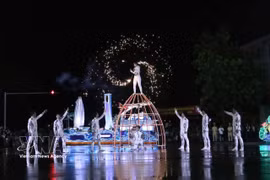 Los artistas desafían la lluvia para ofrecer una impresionante actuación artística. Foto: VNA
