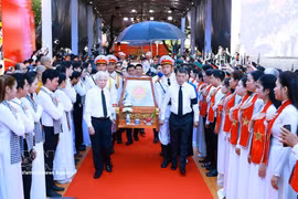 El primer ministro Le Minh Hung y el expresidente Nguyen Minh Triet, junto con otros delegados, acompañan los restos de mártires desde el parque Le Thi Rieng. Foto: VNA