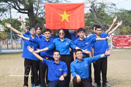 Miembros de la Unión de Jóvenes Comunistas Ho Chi Minh en Cuba izan la bandera nacional. Foto: VNA