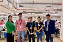 Le Ngoc Toan, primer secretario y jefe de la Junta Directiva de trabajadores y expertos en Malasia (primero a la derecha) y trabajadores vietnamitas en la empresa Ramatex Textiles. (Fuente: VNA)