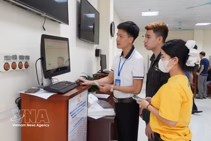 Funcionarios del Centro de Servicios Administrativos Públicos del barrio de Vinh Yen guían a los residentes en el proceso de registro matrimonial en línea a través del portal de servicios públicos. (Foto: VNA)