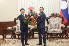 El embajador de Vietnam en Laos, Nguyen Minh Tam, transmite el arreglo floral de felicitación del primer ministro vietnamita Le Minh Hung al premier laosiano Saleumxay Kommasitt. (Foto: VNA) 