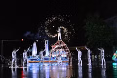 Los artistas desafían la lluvia para ofrecer una impresionante actuación artística. Foto: VNA
