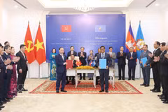 El miembro del Buró Político y miembro permanente del Secretariado del Comité Central del Partido Comunista de Vietnam, Tran Cam Tu, y el vicepresidente del Partido Popular de Camboya (CPP) y jefe del Comité Permanente del Comité Central del CPP, Say Chhum, presencian en Phnom Penh la entrega de documentos de cooperación. (Foto: VNA)