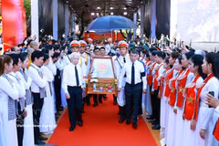 El primer ministro Le Minh Hung y el expresidente Nguyen Minh Triet, junto con otros delegados, acompañan los restos de mártires desde el parque Le Thi Rieng. Foto: VNA