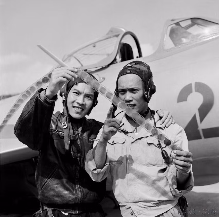 Los pilotos Tran Hanh y Pham Ngoc Lan (derecha), dos excelentes efectivos de la Fuerza Aérea de Vietnam que derribaron muchos aviones estadounidenses, revisan los resultados de la batalla grabados en película fotográfica después de completar su misión de combate. (Fuente: VNA)
