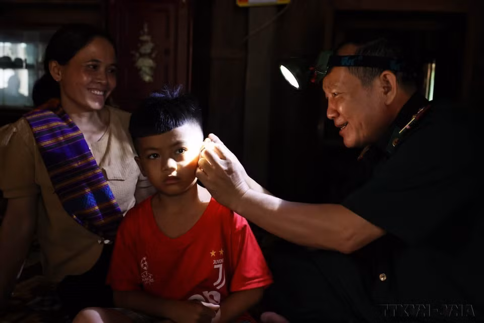 El mayor Nguyen Hong Dung, oficial médico del puesto fronterizo de Huong Lap (Guardia fronteriza de la provincia central de Quang Tri), no duda en escalar montañas y cruzar arroyos para visitar a los habitantes de la etnia Van Kieu que viven en las laderas occidentales de Truong Son para ofrecer medicamentos y darles instrucciones sobre la prevención de enfermedades. (Fuente: VNA)