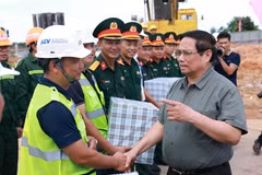 El primer ministro Pham Minh Chinh (derecha) se reúne con las unidades encargadas de la construcción de la terminal T2 del Aeropuerto Dong Hoi (Foto: VNA)