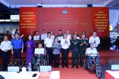 El subsecretario del Comité del Partido de Ciudad Ho Chi Minh y presidente del Comité municipal del Frente de la Patria de Vietnam, Nguyen Phuoc Loc (cuarto desde la derecha), entrega obsequios a las familias beneficiarias de políticas sociales. (Foto: VNA)