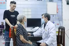 Un médico del Hospital Cho Ray realiza un examen de salud a una anciana en el centro médico del barrio de Cho Lon. (Foto: VNA)