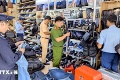 Las autoridades inspeccionan y confiscan una gran cantidad de productos de origen desconocido en una tienda (Foto: VNA)