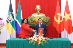 El miembro del Buró Político y permanente del Secretariado del Comité Central del PCV, Tran Cam Tu, y la vicesecretaria general del ANC de Sudáfrica, Nomvula Mokonyane, intercambian un documento de cooperación entre los dos Partidos (Foto: VNA)