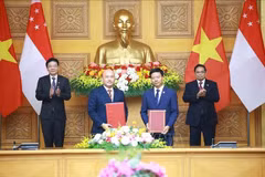 El primer ministro de Vietnam, Pham Minh Chinh (derecha), y su homólogo singapurense, Lawrence Wong (izquierda), presencian el intercambio del acuerdo de cooperación entre la Asociación de Amistad Vietnam-Singapur y la Fundación Internacional de Singapur. (Foto: VNA)