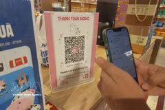 Un cliente realiza un pago mediante código QR. (Foto: VNA)