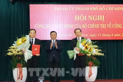 El miembro del Buró Político y permanente del Secretariado del Comité Central del PCV, Tran Cam Tu, entrega las decisiones del Buró Político a Tran Luu Quang y Nguyen Van Nen (Foto: VNA)